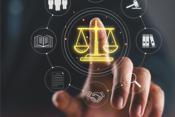 Person touching a digital interface with justice scale icon at the center, surrounded by legal symbols like a courthouse, gavel, book, and handshake, representing modern legal services.